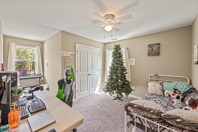 carpeted bedroom featuring ceiling fan, a closet, visible vents, and baseboards