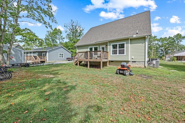 rear view of property featuring a shingled roof, a lawn, crawl space, central AC, and a wooden deck