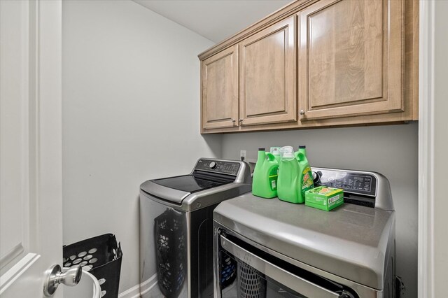 washroom featuring cabinet space and separate washer and dryer