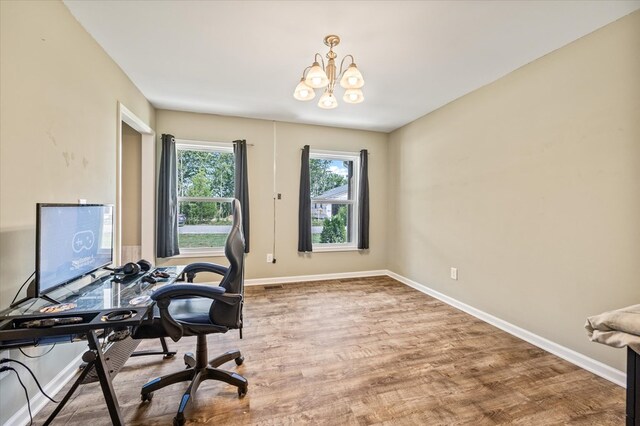 office featuring a notable chandelier, wood finished floors, and baseboards