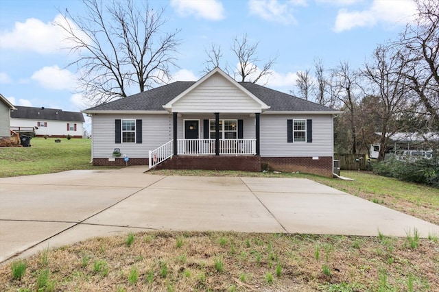 view of front of home with covered porch, a shingled roof, crawl space, and a front yard