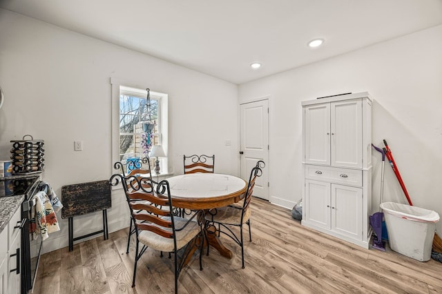 dining space featuring baseboards, light wood-type flooring, and recessed lighting