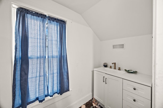 interior space featuring visible vents, vaulted ceiling, vanity, and baseboards