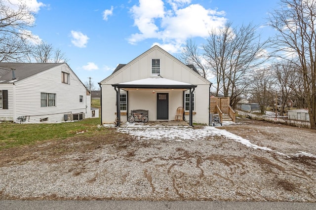 view of front of property with board and batten siding, covered porch, and stairs