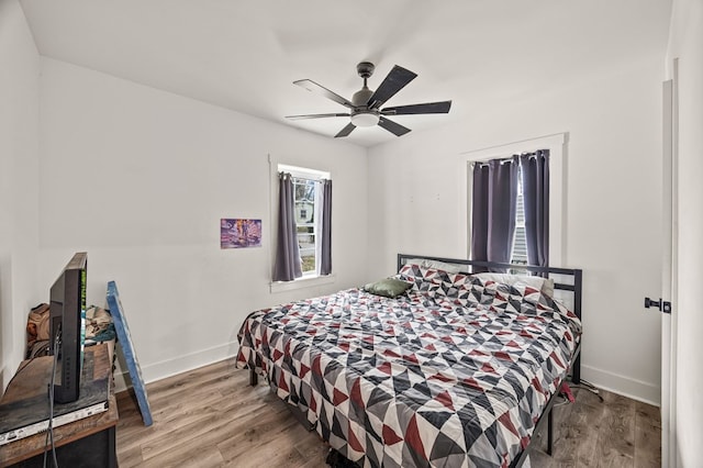 bedroom with ceiling fan, baseboards, and wood finished floors