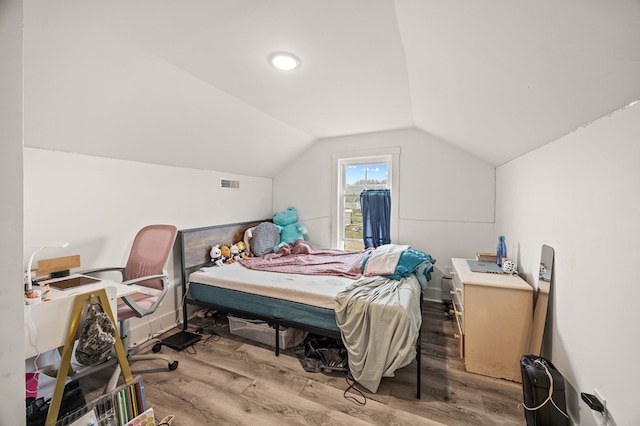 bedroom featuring vaulted ceiling, light wood finished floors, and visible vents