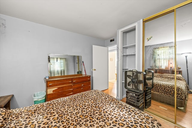 bedroom with a closet, visible vents, and wood finished floors