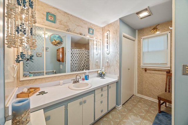 bathroom featuring visible vents, a shower with shower curtain, vanity, and baseboards