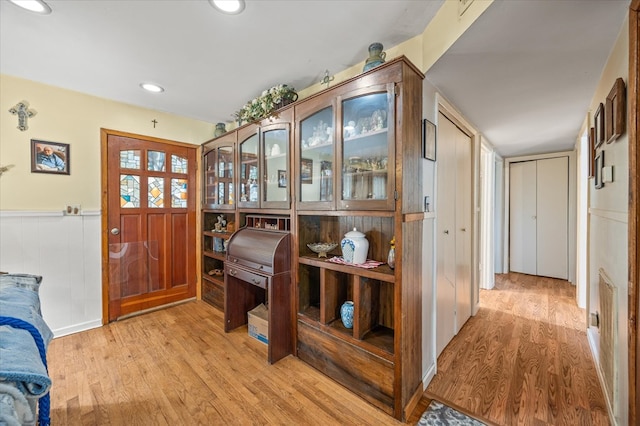 foyer with recessed lighting, wainscoting, and light wood finished floors