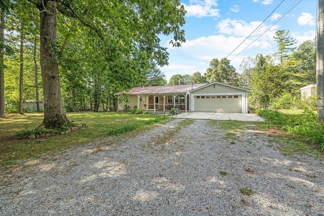 single story home with a garage, gravel driveway, and a front lawn