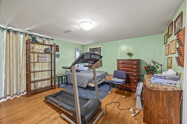 exercise area with visible vents and wood finished floors