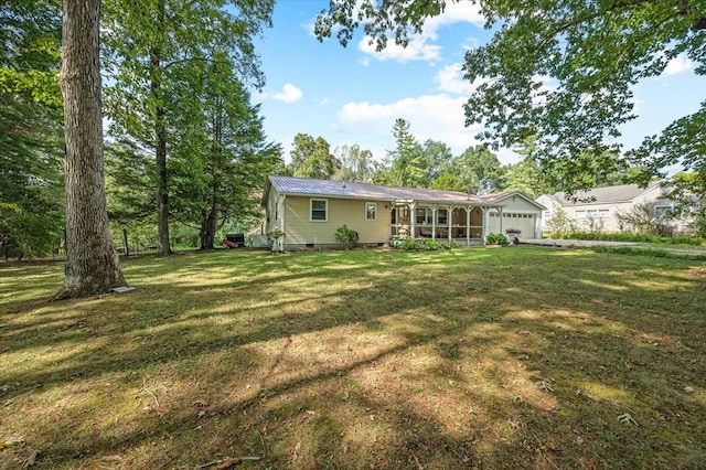 rear view of property with a garage and a yard