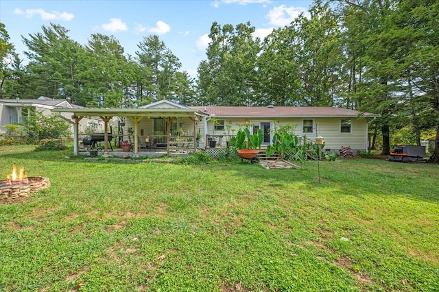 back of property featuring metal roof, a yard, and a fire pit