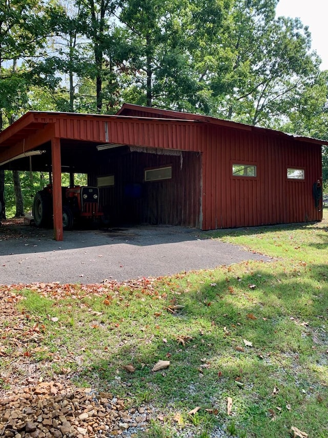 view of pole building with a carport and a lawn