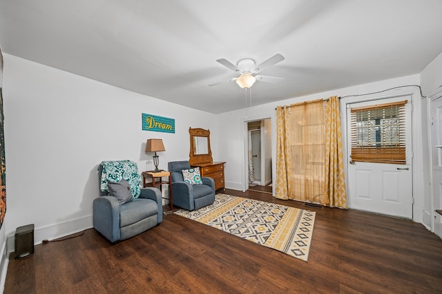 living area featuring baseboards, a ceiling fan, and wood finished floors