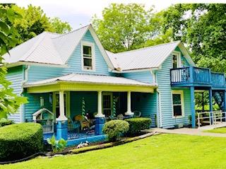 back of house with a porch and a lawn