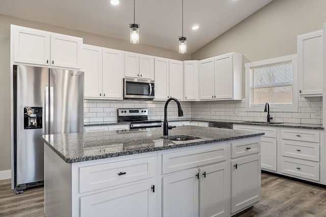 kitchen featuring dark wood-style floors, stainless steel appliances, lofted ceiling, and a sink