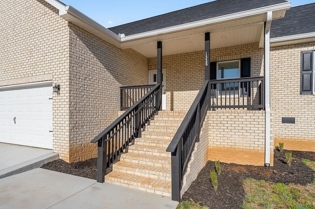 property entrance featuring brick siding, a porch, a shingled roof, and a garage