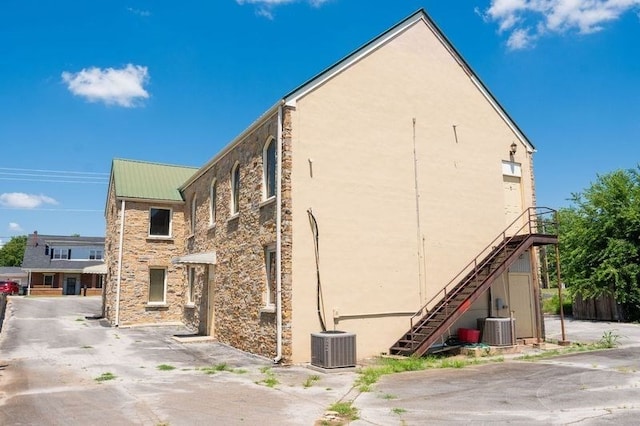 view of property featuring central AC unit and stairway