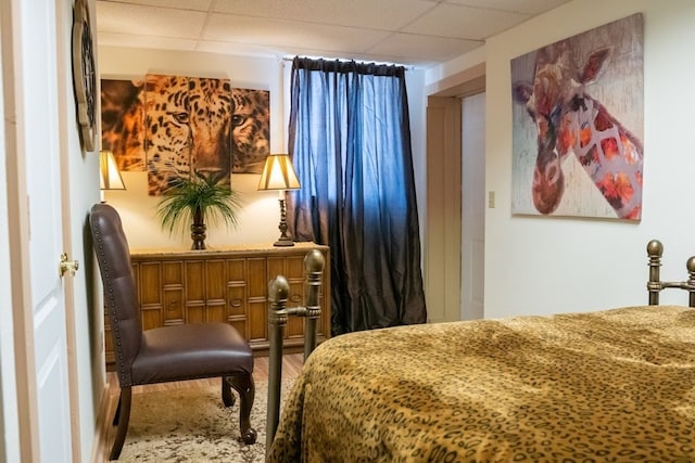 bedroom featuring a paneled ceiling and wood finished floors