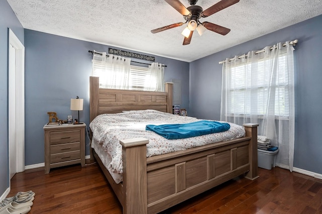 bedroom featuring baseboards, dark wood finished floors, and a textured ceiling