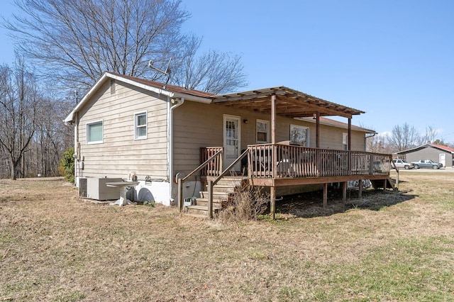 view of front of home featuring a front yard, stairway, a wooden deck, and central AC unit