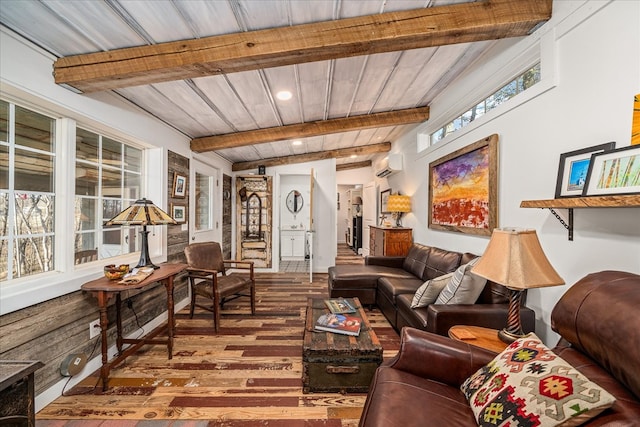 living room with wood ceiling, a wall unit AC, wood finished floors, and beam ceiling