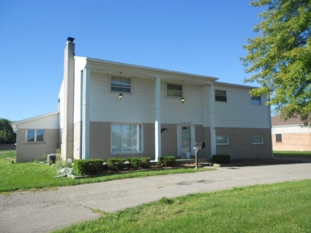 rear view of property featuring a lawn