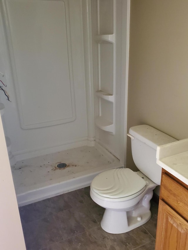 bathroom with tile patterned floors, a shower, vanity, and toilet