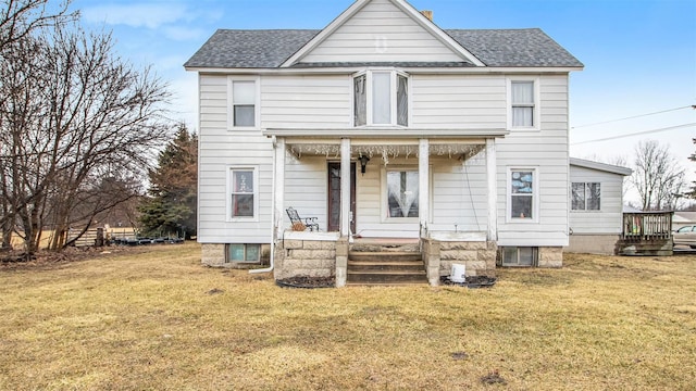 back of property featuring a lawn and covered porch