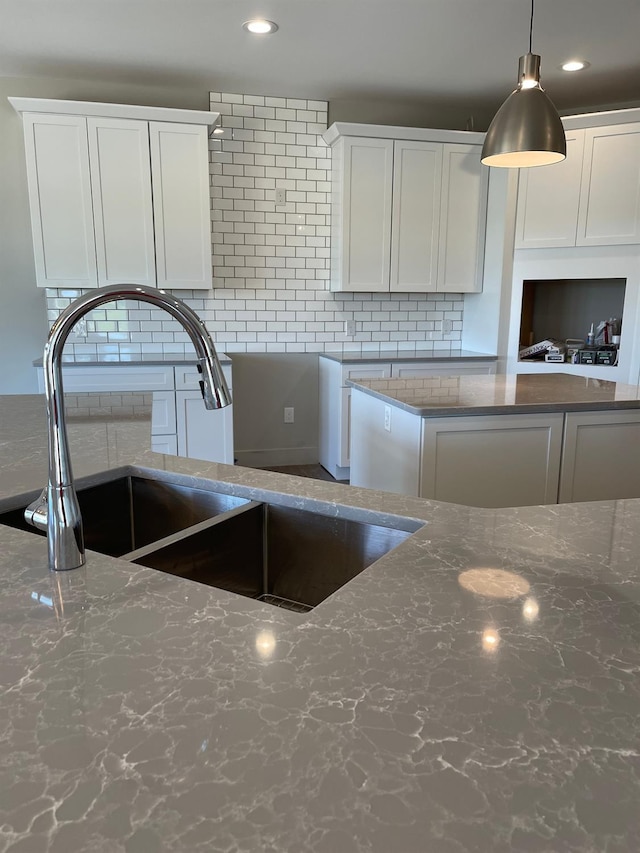 4224 Duck Dr Unit 5, Ann Arbor, MI 48103 - kitchen with a sink, backsplash, dark stone counters, white cabinetry, and recessed lighting