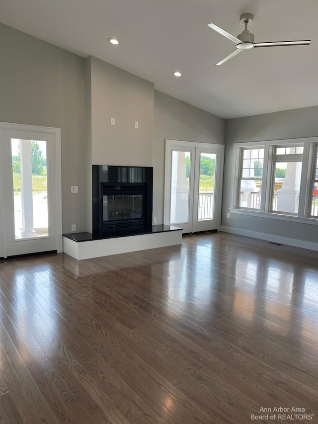 unfurnished living room featuring ceiling fan, dark wood-type flooring, and high vaulted ceiling