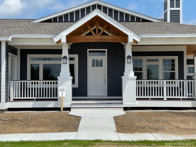 4224 Duck Dr Unit 5, Ann Arbor, MI 48103 - property entrance with covered porch, a shingled roof, and a chimney