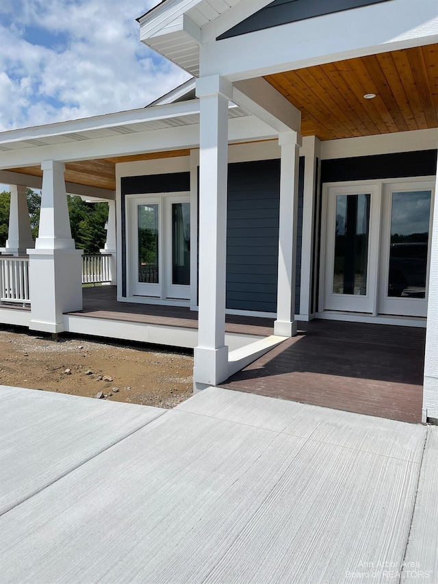 view of exterior entry featuring covered porch