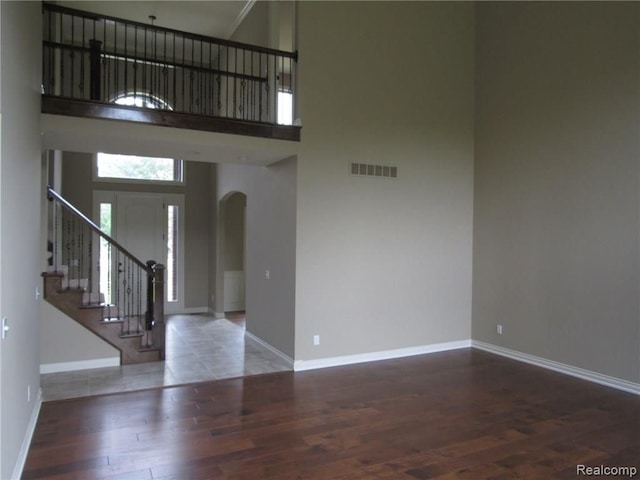 foyer entrance with hardwood / wood-style flooring and a towering ceiling