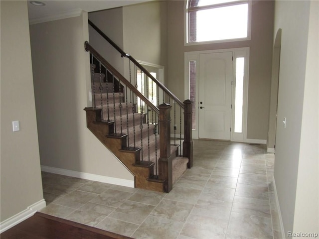 foyer entrance with crown molding and a high ceiling