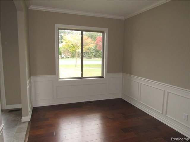 empty room with crown molding and dark hardwood / wood-style flooring