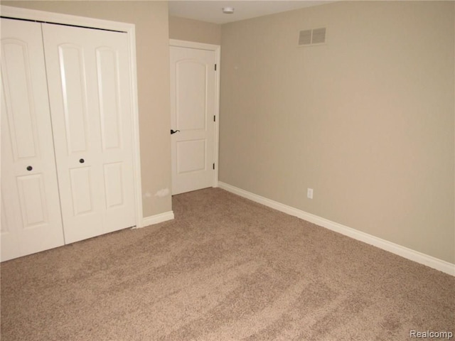 unfurnished bedroom featuring carpet flooring and a closet