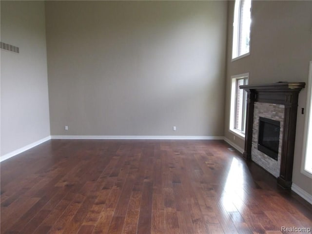 72859 Sorrel Dr, Bruce, MI 48065 - unfurnished living room with healthy amount of natural light, a stone fireplace, and dark wood finished floors