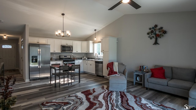 living room with sink, dark wood-type flooring, and vaulted ceiling