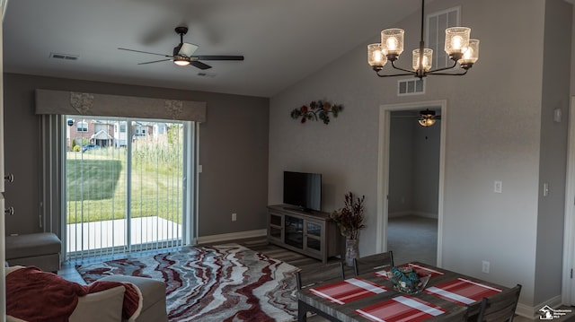 carpeted living room with lofted ceiling and ceiling fan with notable chandelier