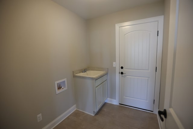 laundry area featuring cabinets, washer hookup, light tile patterned floors, and sink