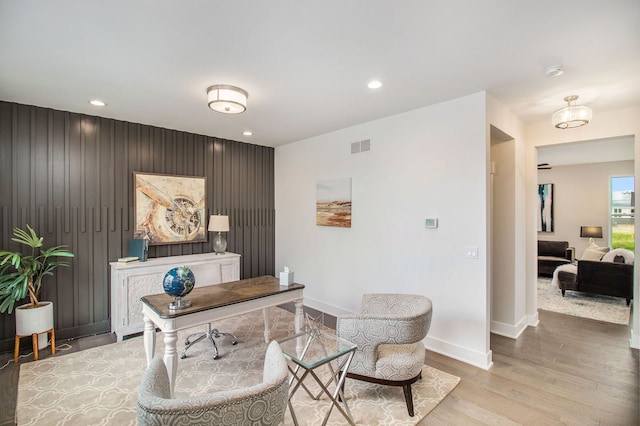 office featuring light hardwood / wood-style flooring and wooden walls