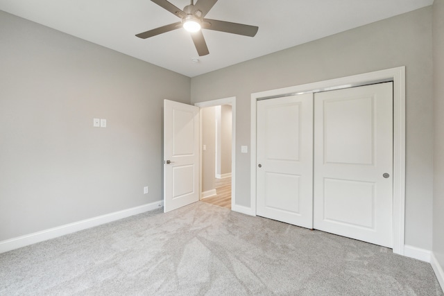 unfurnished bedroom featuring ceiling fan, light colored carpet, and a closet