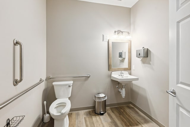 bathroom with hardwood / wood-style floors, toilet, and sink