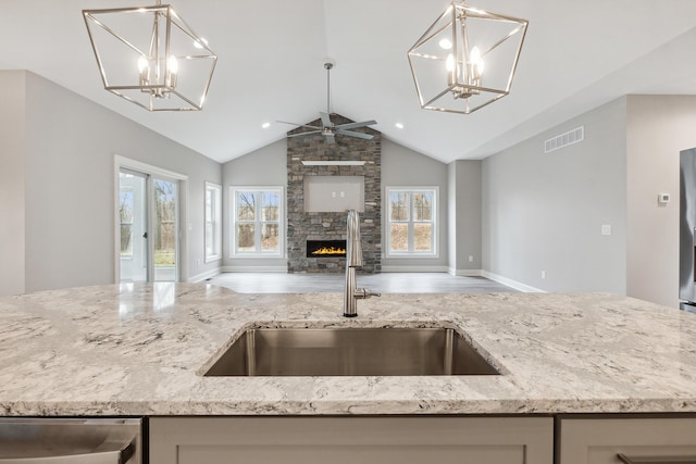 1140 Lochaven Cir Unit 10B, Hillsdale, MI 49242 - kitchen featuring open floor plan, a sink, light stone countertops, a ceiling fan, and high vaulted ceiling