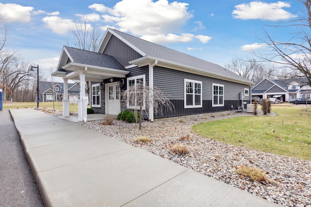 1140 Lochaven Cir Unit 10B, Hillsdale, MI 49242 - view of home's exterior featuring a lawn, cooling unit, and a shingled roof