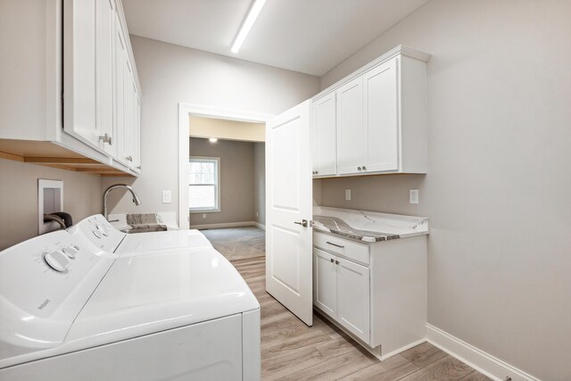 1140 Lochaven Cir Unit 10B, Hillsdale, MI 49242 - washroom with cabinet space, washer and clothes dryer, baseboards, and light wood-style floors