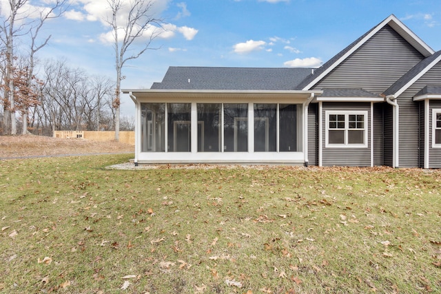 back of property featuring a sunroom and a yard