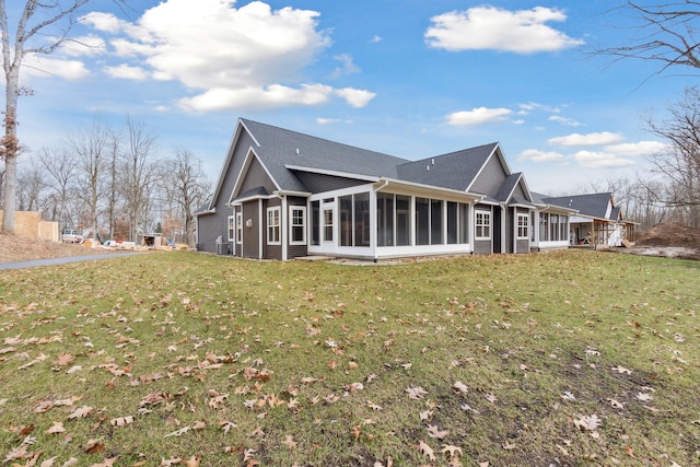 back of property with a yard and a sunroom